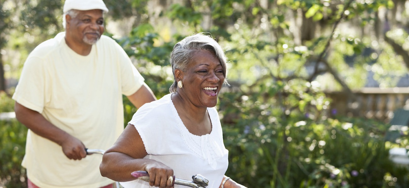 Homepage rotator with senior couple riding bikes together in a park